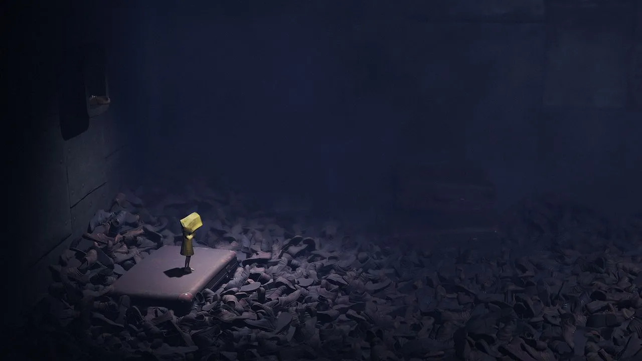alt: Six hiding under a table from an enemy in Little Nightmares