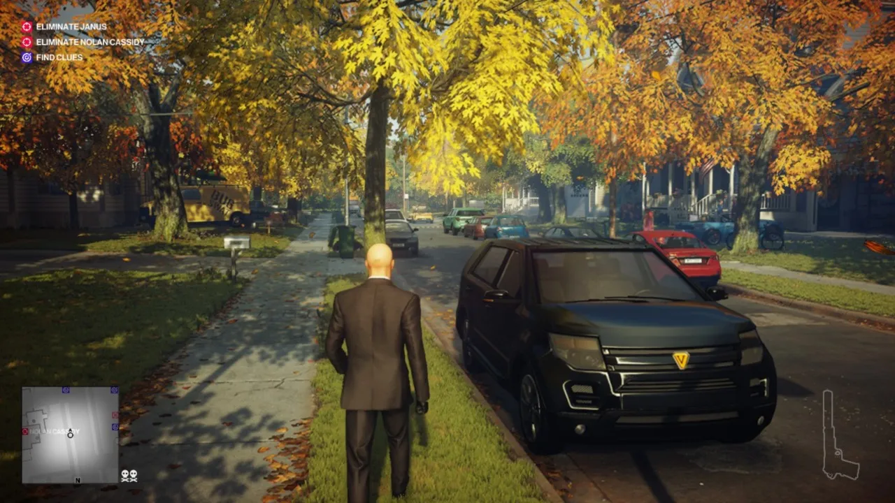 alt text: Hitman 2 gameplay screenshot showing Agent 47 aiming a pistol in a crowded environment.