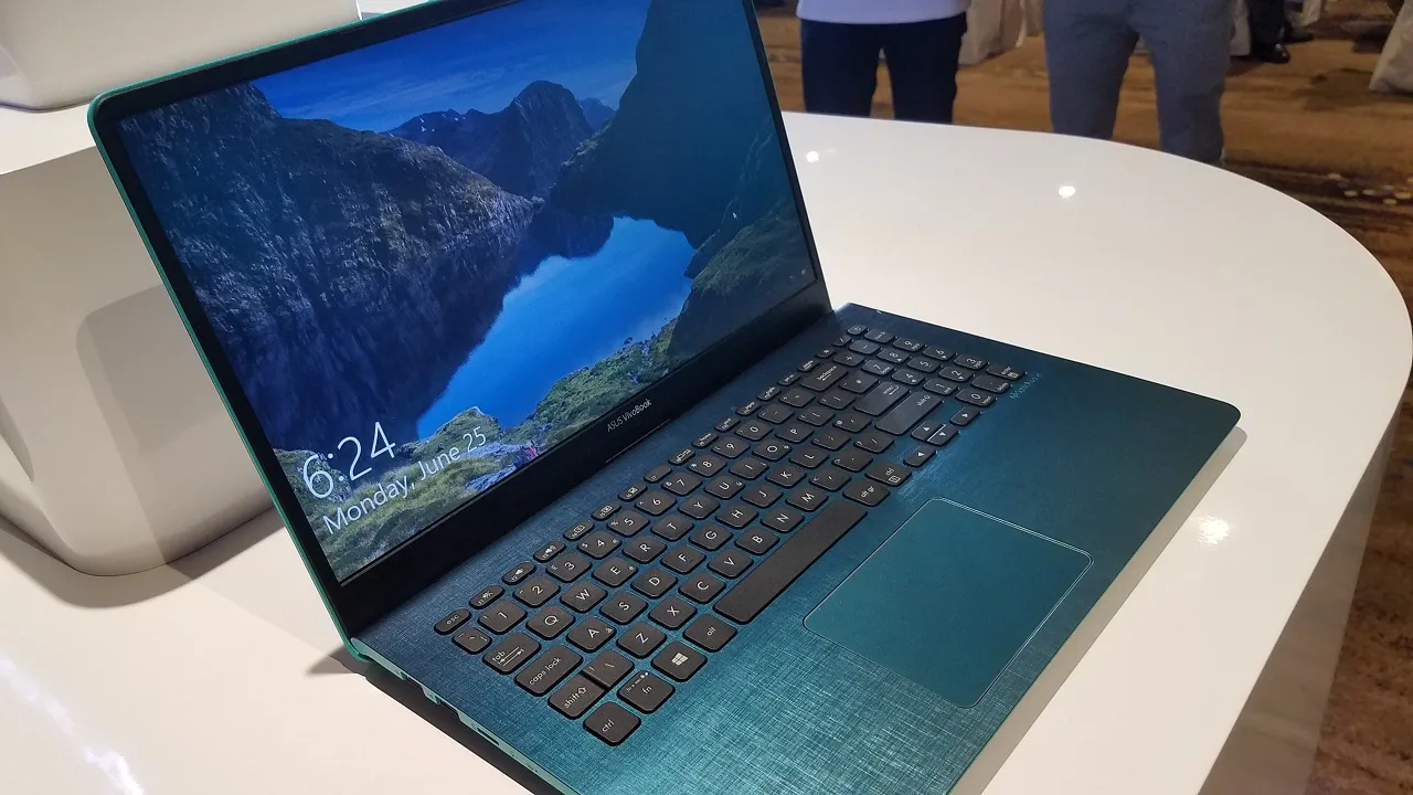 Three ASUS VivoBook laptops displayed on a table